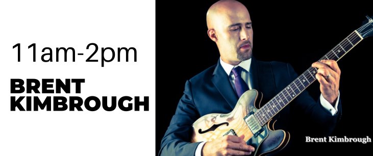 Brent Kimbrough in a suit holding a guitar