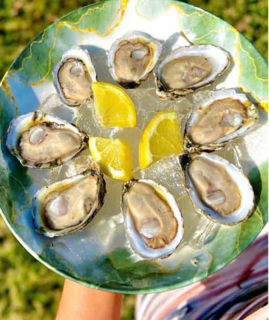 eight oysters arranged in a circle around three pieces of lemon